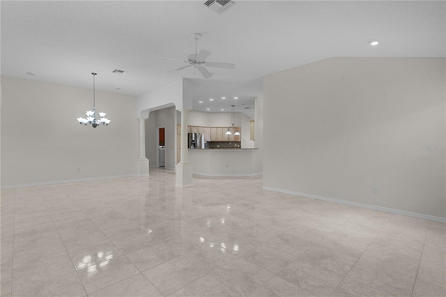 unfurnished living room featuring ceiling fan with notable chandelier, a textured ceiling, and ornate columns