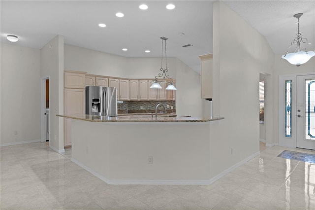 kitchen with light brown cabinetry, backsplash, pendant lighting, and stainless steel refrigerator with ice dispenser