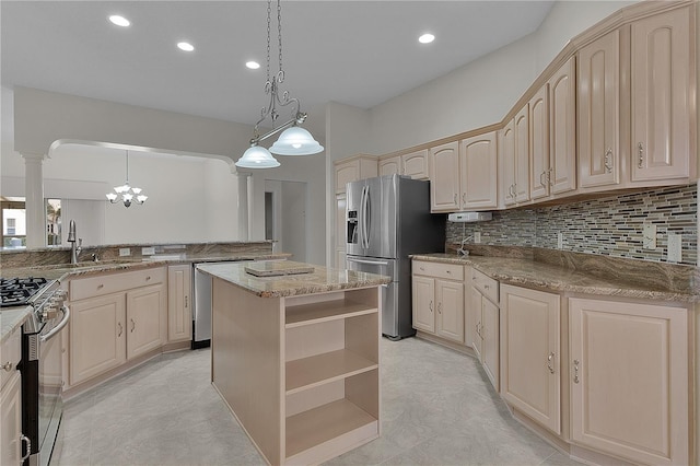 kitchen with sink, appliances with stainless steel finishes, hanging light fixtures, a kitchen island, and kitchen peninsula