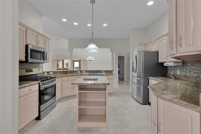 kitchen featuring appliances with stainless steel finishes, pendant lighting, decorative columns, decorative backsplash, and kitchen peninsula