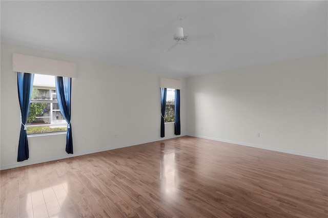 empty room with ceiling fan and light wood-type flooring