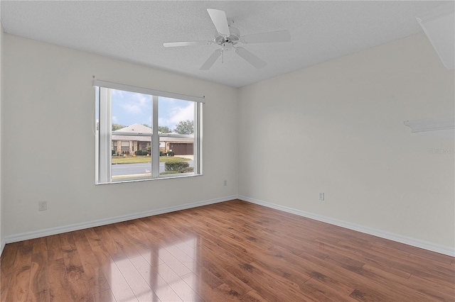 empty room with hardwood / wood-style flooring, a textured ceiling, and ceiling fan