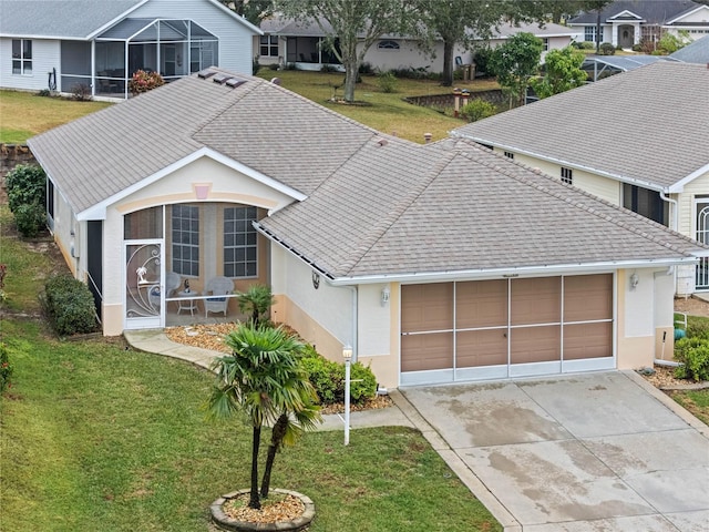 view of front of home featuring a garage, a front lawn, and a sunroom