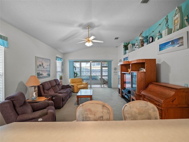 living room with ceiling fan, light colored carpet, vaulted ceiling, and a textured ceiling