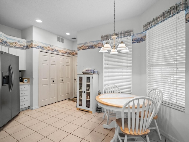 dining room with a chandelier and light tile patterned flooring