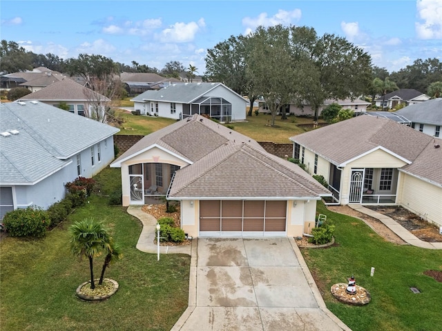 view of front of home with a front lawn, a garage, and a sunroom