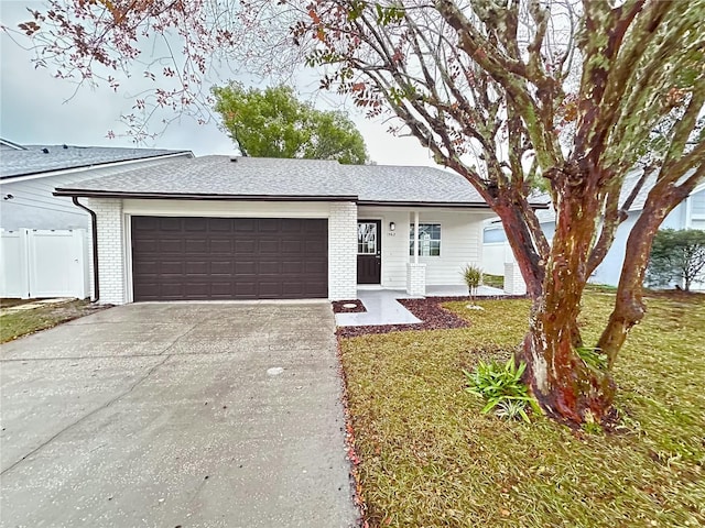 single story home featuring a garage and a front lawn