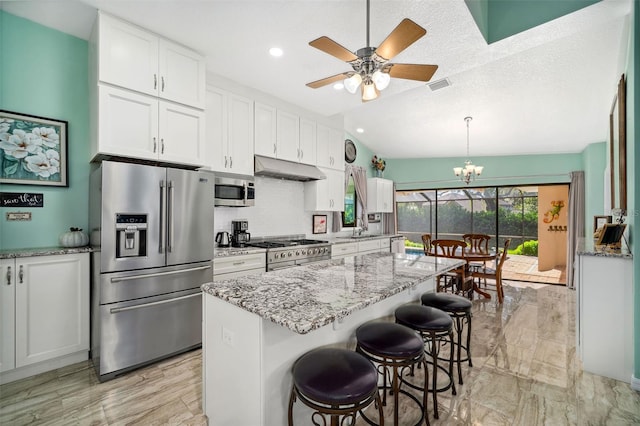 kitchen with high end appliances, light stone counters, a center island, a kitchen breakfast bar, and white cabinets