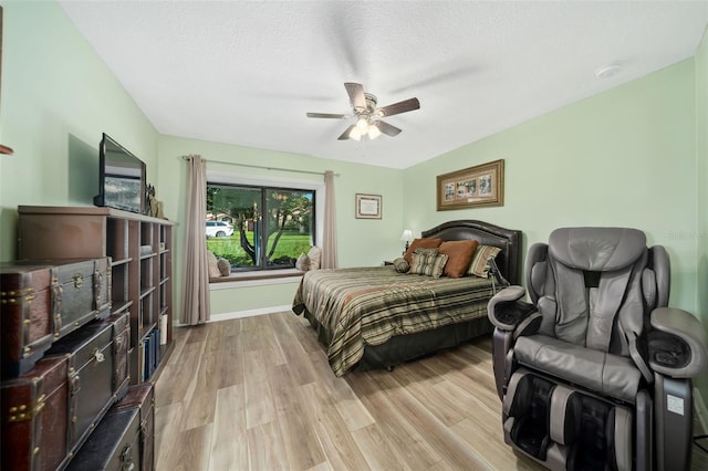 bedroom featuring ceiling fan, a textured ceiling, and light wood-type flooring