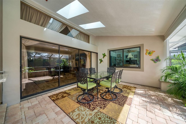 sunroom featuring vaulted ceiling with skylight