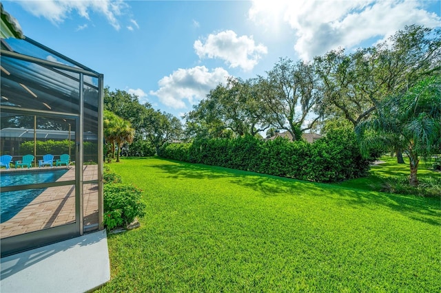 view of yard featuring a fenced in pool and glass enclosure