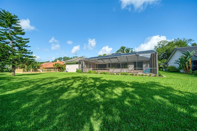 rear view of house featuring a lanai and a yard