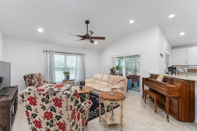 living room featuring ceiling fan, sink, light tile patterned floors, and lofted ceiling