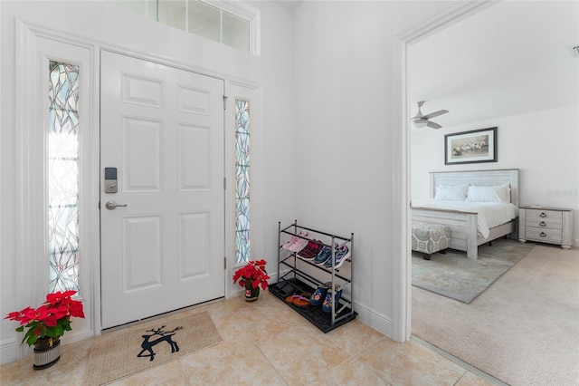 carpeted foyer entrance with ceiling fan