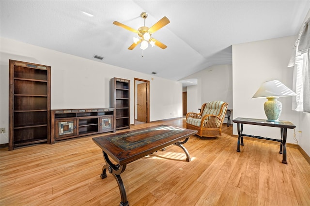 living room with ceiling fan, lofted ceiling, and light wood-type flooring