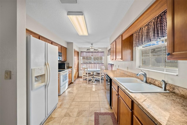 kitchen featuring light tile patterned floors, ceiling fan, a textured ceiling, black appliances, and sink