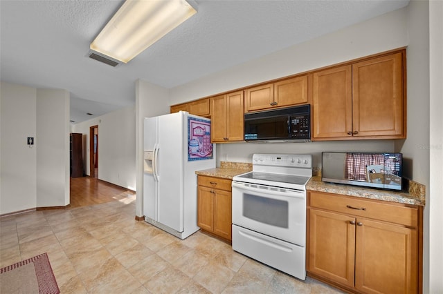 kitchen featuring a textured ceiling and white appliances