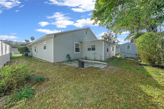 rear view of house featuring central AC unit, a patio area, and a yard