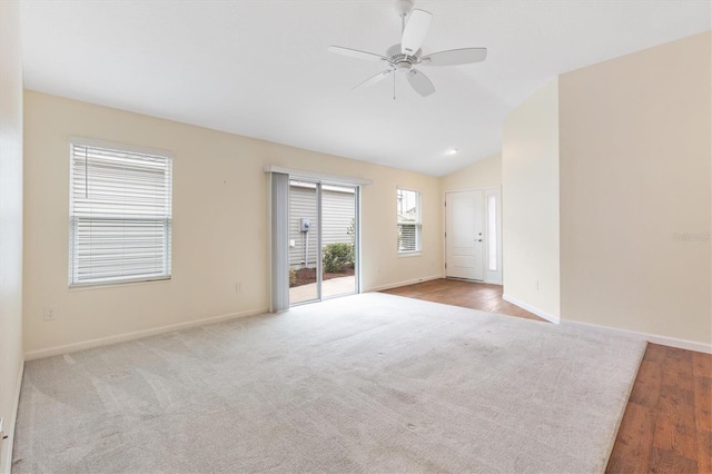 empty room featuring lofted ceiling, light colored carpet, and ceiling fan