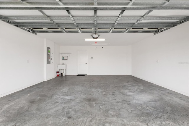 garage featuring sink, a garage door opener, and electric panel