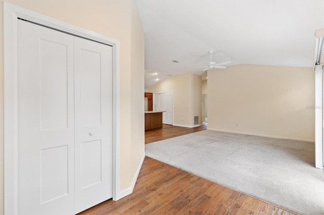 interior space featuring ceiling fan, vaulted ceiling, and wood-type flooring