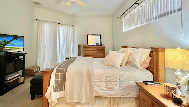 bedroom featuring multiple windows, ceiling fan, and light carpet