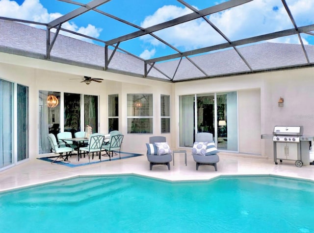 view of swimming pool with area for grilling, a patio area, ceiling fan, and glass enclosure