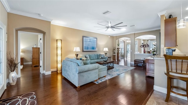 living room featuring dark hardwood / wood-style floors, ceiling fan, and ornamental molding