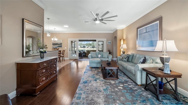 living room featuring ceiling fan with notable chandelier, dark hardwood / wood-style flooring, and crown molding