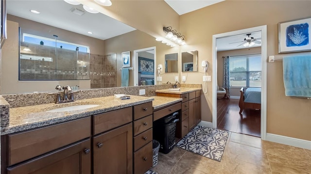 bathroom with ceiling fan, tiled shower, vanity, and tile patterned flooring