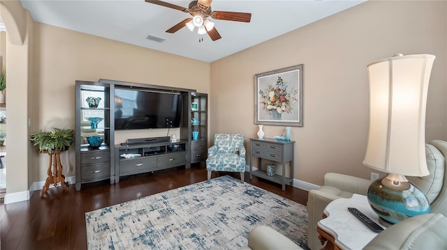 living room featuring ceiling fan and dark hardwood / wood-style floors