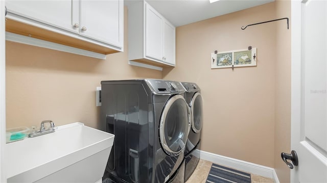 washroom featuring sink, light tile patterned floors, cabinets, and separate washer and dryer