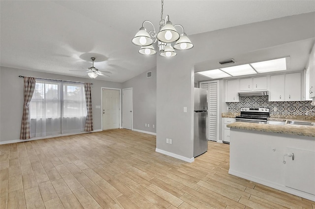 kitchen featuring decorative backsplash, white cabinets, pendant lighting, stainless steel appliances, and ceiling fan with notable chandelier