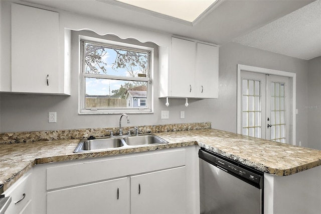 kitchen featuring a textured ceiling, dishwasher, white cabinetry, sink, and kitchen peninsula