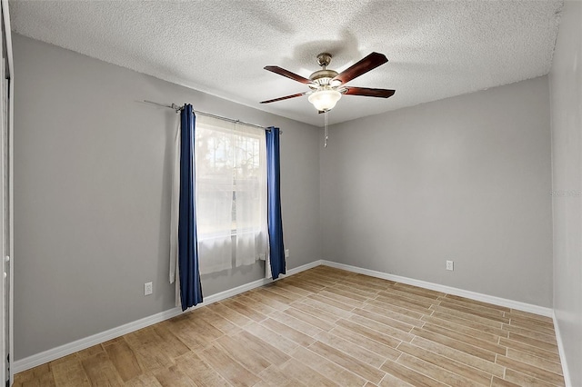 spare room with light wood-type flooring, a textured ceiling, and ceiling fan