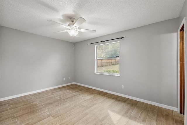 spare room with ceiling fan, a textured ceiling, and light wood-type flooring