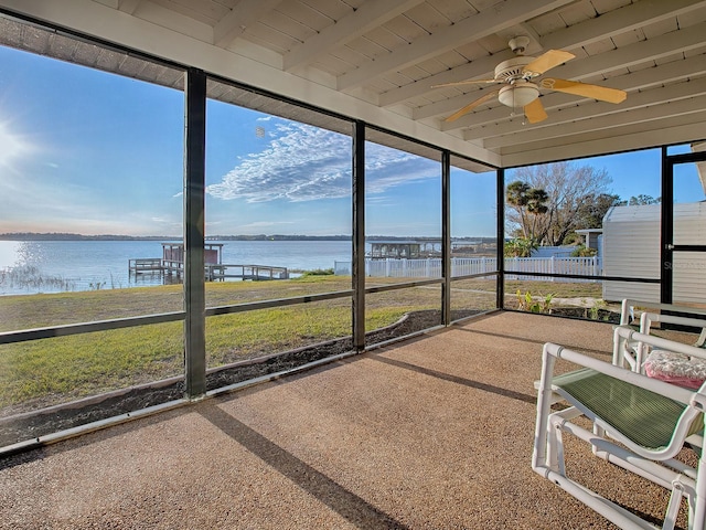 sunroom with ceiling fan, a water view, wooden ceiling, and beam ceiling