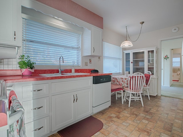 kitchen with pendant lighting, white cabinetry, dishwasher, sink, and plenty of natural light