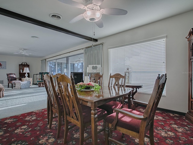 dining area with ceiling fan and dark colored carpet