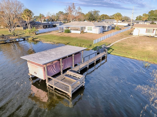 dock area featuring a water view and a lawn