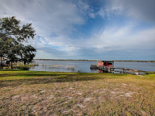 view of dock featuring a water view and a lawn