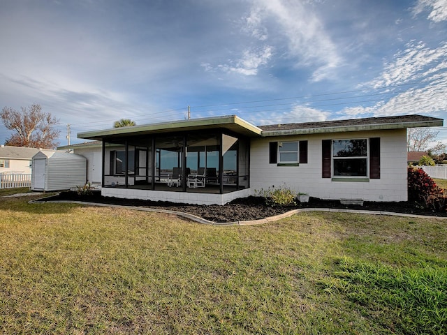 rear view of property featuring a yard and a sunroom