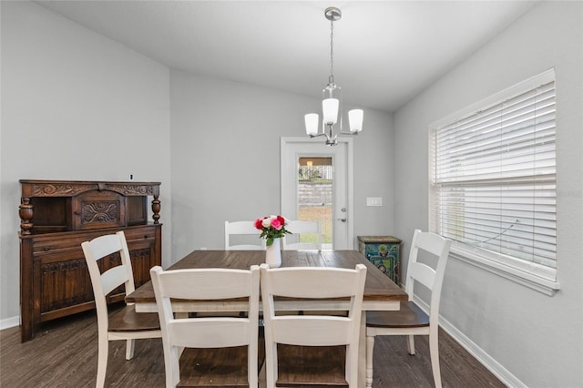 dining area featuring dark hardwood / wood-style flooring and an inviting chandelier