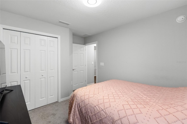 bedroom with light colored carpet, a closet, and a textured ceiling