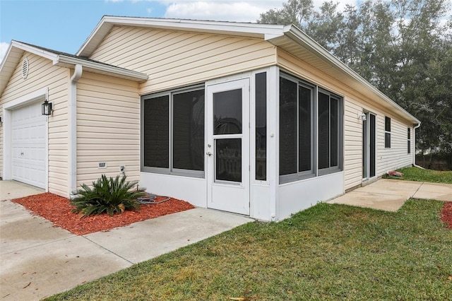 view of side of home featuring a garage, a sunroom, and a lawn