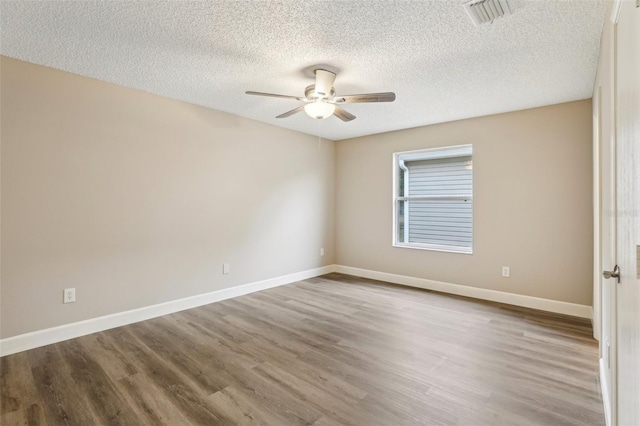 spare room with hardwood / wood-style flooring, ceiling fan, and a textured ceiling