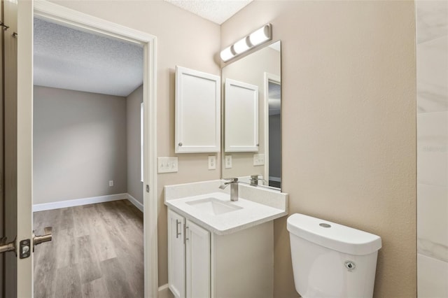 bathroom with vanity, hardwood / wood-style floors, a textured ceiling, and toilet