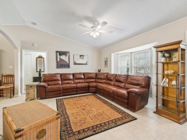 tiled living room featuring vaulted ceiling, ornamental molding, ceiling fan, and a textured ceiling