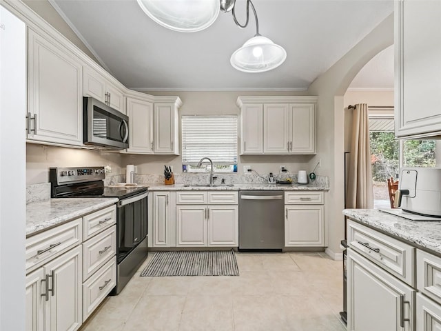 kitchen featuring white cabinetry, sink, decorative light fixtures, and stainless steel appliances