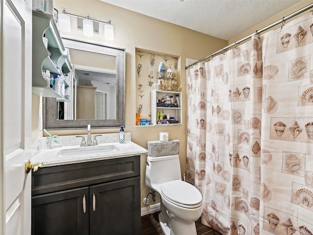 bathroom featuring walk in shower, vanity, toilet, and a textured ceiling